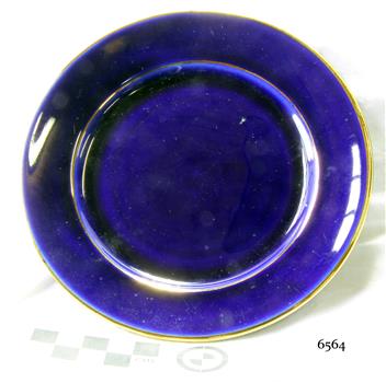 Round royal blue ceramic plate with a gold rim.