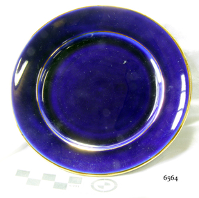 Round royal blue ceramic plate with a gold rim.