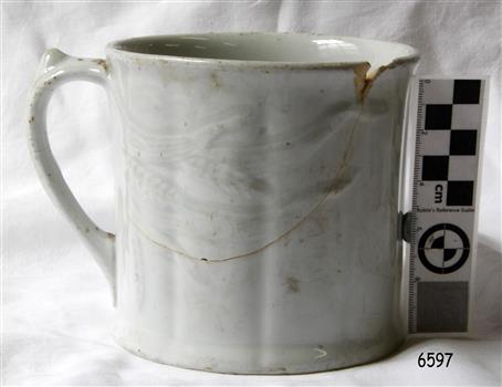 Wide white ceramic mug, vertical indented line pattern on body, straight sides