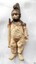 Cream figurine, unpainted, dressed as a soldier, holding a weapon. Stained surface.