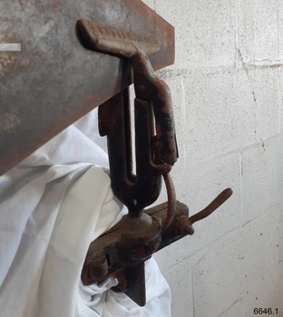 Close up of vice shows the lower clamp's lever and the jaws holding the hand saw