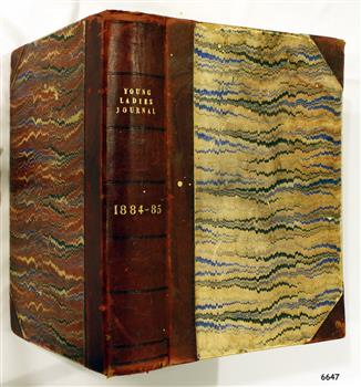 Hardcover, brown-blue-cream patterned cover, leather reinforced spine, gold embossing