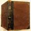 Brown hardcover, leather bound and leather reinforced corners, gold embossed lettering on spine