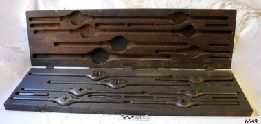 Wooden box with fitted compartments containing metal tools