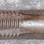 Edge of tool has is shaped for cutting. End is flat and square