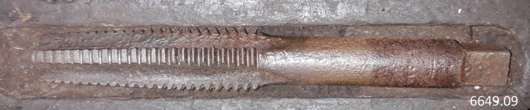 Edge of tool has is shaped for cutting. End is flat and square