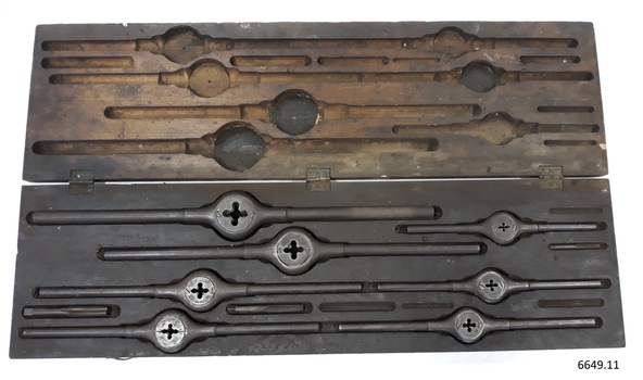 Lid of box has hollowed compartments shaped to fit around the metal tools in the base