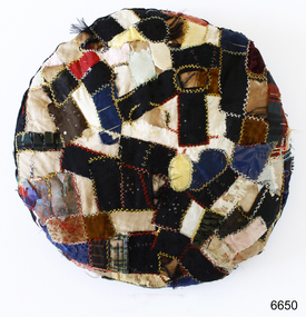 Round patchwork cushion with exposed cross stitching 
