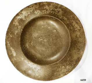 Round metal plate with broad rim and shallow bowl