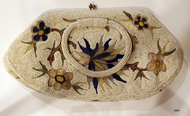 Purse has beaded floral design with round beaded handles and metal clasp
