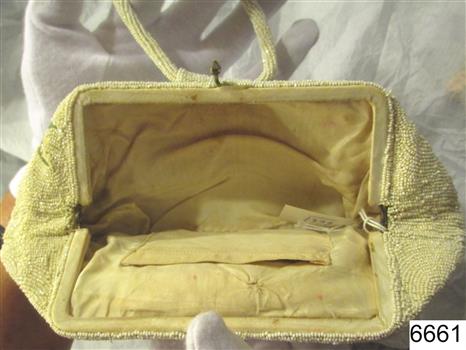 Evening bag has has white silky fabric lining