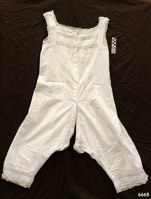Fine white cotton undergarment with pin tucks on bodice and lace inserts. Garment combines both chemise and bloomers