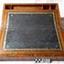 Leather writing surface has gold painted decorative border