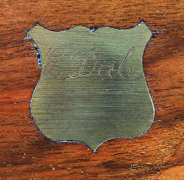 Shield shaped brass plaque has an inscription 