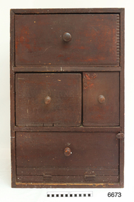 Wooden cupboard with four sections, each wit a round wooden knob