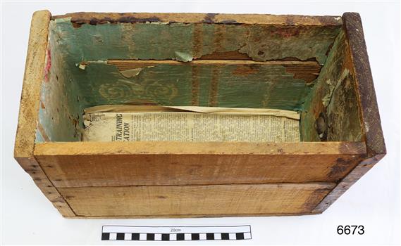 Drawer has newspaper on the base and green paper lining on the sides