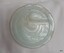 Milky blue glass disc with swirly lines on surface and chips on edge
