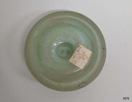 Opaque aqua cap liner, disc-shaped with a white label