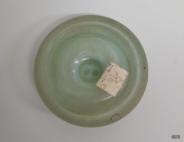 Opaque aqua cap liner, disc-shaped with a white label