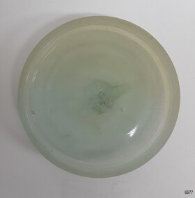 Opaque blue glass disc with ridge around the edge