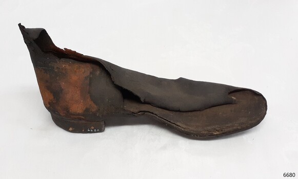 Brown rubber boot, ankle height, with part of the upper foot missing. Rubber is perishing
