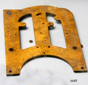 Metal clock frame with drilled holes for anchor points and cutout shapes