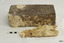 A piece of the concretion has broken off. The sides of the brick are uneven