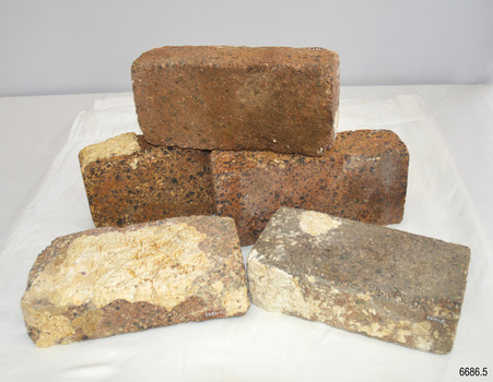 Stack of five house bricks, some with concretion