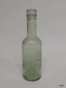 Clear glass bottle with green tinge. Mouth is applied, body is blown into a mould.