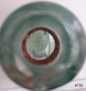 Close-up from mouth of bottle towards enclosed marble