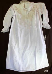 White garment with fancy yoke , neckline and sleeve cuffs