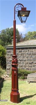 An old style gas lamp light on a wrought iron post.