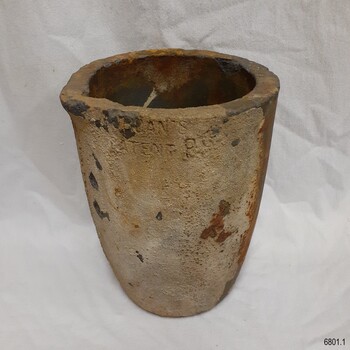 Body of crucible has encrustations on the surface. 