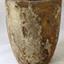 Grey clay has encrusted and orange-stained surface. Inscriptions are on the pot.