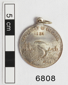 Silver medal has a ring attached, and inscriptions of text and images