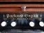 Maker's name and details, gold embossed onto panel above keys
