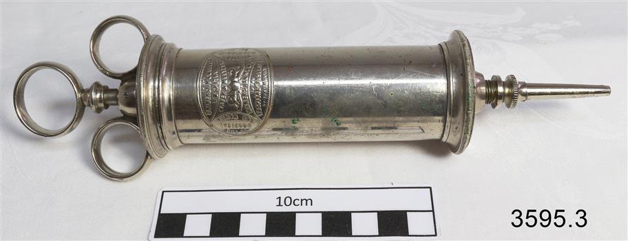 Stainless steel ear syringe with barrel, plunger and tip.