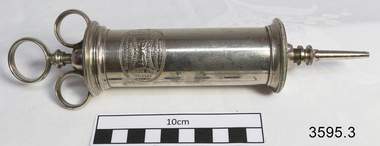 Stainless steel ear syringe with barrel, plunger and tip.