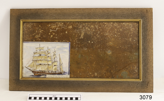 Slate tile in frame, behind glass, with drawing of a ship included
