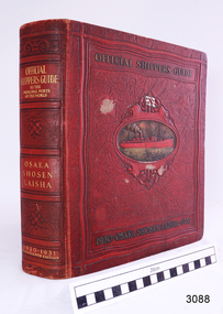 Large red bound book, gold writing and image of a ship etched on the cover. 
