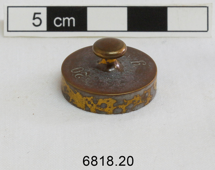 The 20 gram weight used for use by an apothecary. Part of an apothecary set of weights.