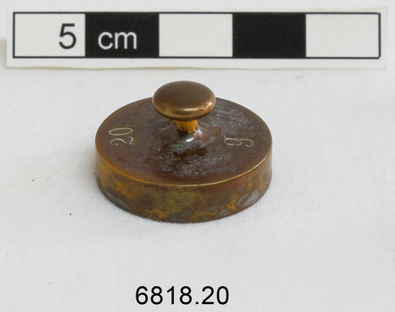 The 20 gram weight used for use by an apothecary. Part of an apothecary set of weights.