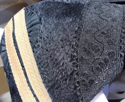 Gold braid has been added over the black lace