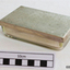 A small rectangular glass container with a metal lid containing lint, angle-ended tweezers, glass syringe and a separate metal end piece.