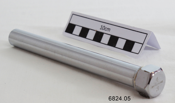 A long metal tube containing 3 copper coloured medical instruments 