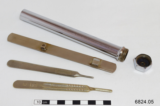 A long metal tube containing 3 copper coloured medical instruments 
