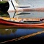Orange rowing boat with black pinstripes, in the water