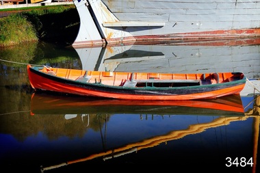 Orange rowing boat with black pinstripes, in the water