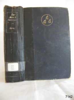 A blue hard cover with a black stripe, a golden emblem, book's name on the spine in white font