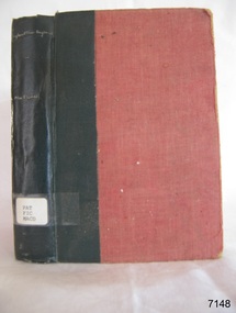 Red hard cover book with black tape, tile in small white font